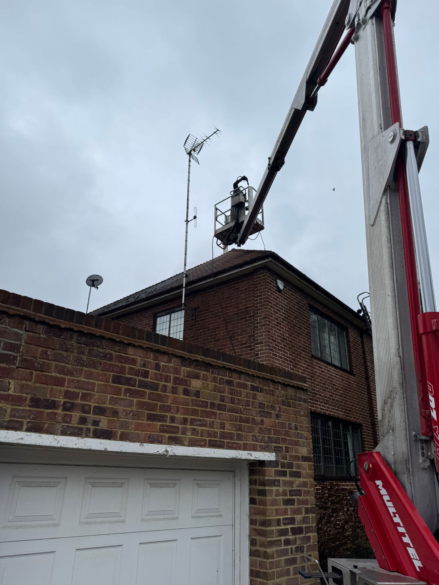 Cherry picker positioned for roof cleaning work